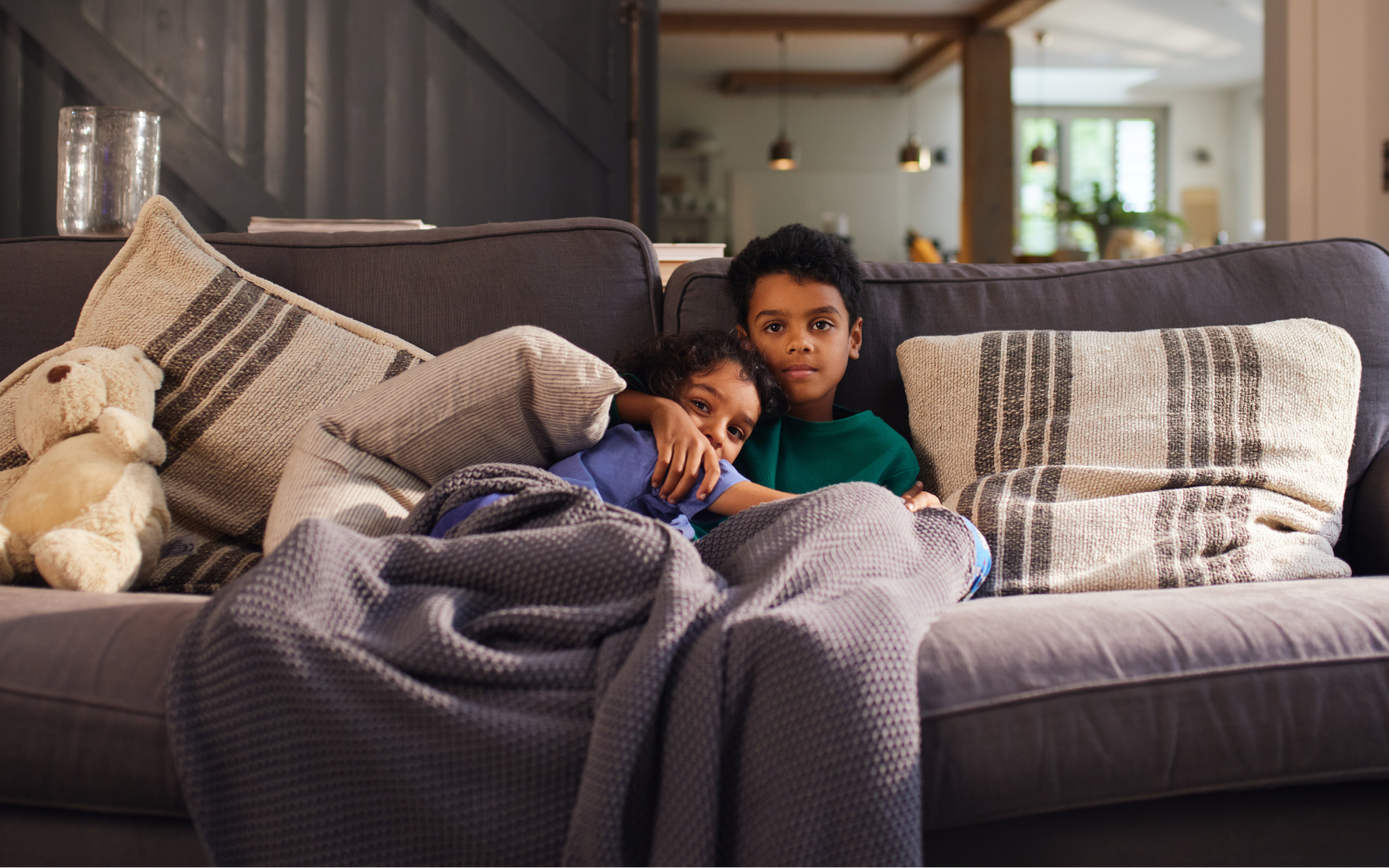 Family cuddled under blanket to help reduce energy cost